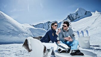 Ein Paar sitzt im Schnee am Kitzsteinhorn