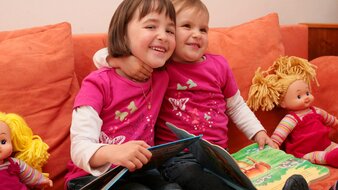 Zwei spielende Kinder auf einer Couch